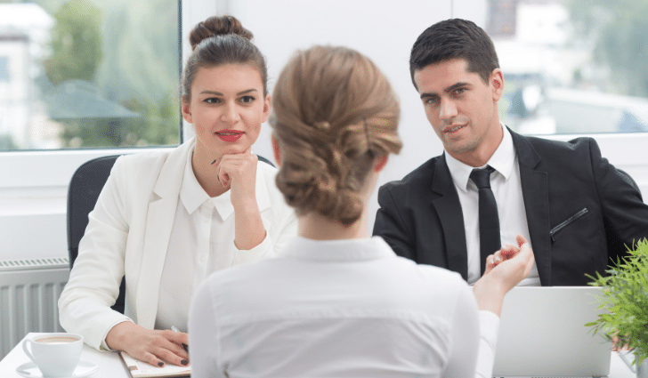 Job interview two interviewers in suits speak with a candidate