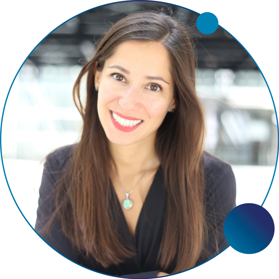 Smiling woman portrait with long brown hair wearing a silver pendant necklace in a circular blue framed frame